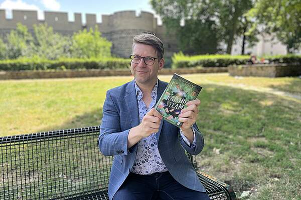 Person hält Buch in die Kamera