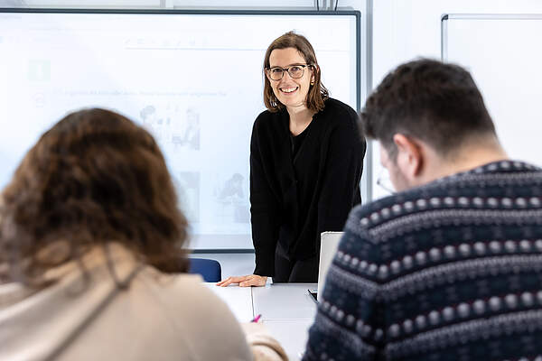 Lehrerin mit zwei Teilnehmenden im Unterricht